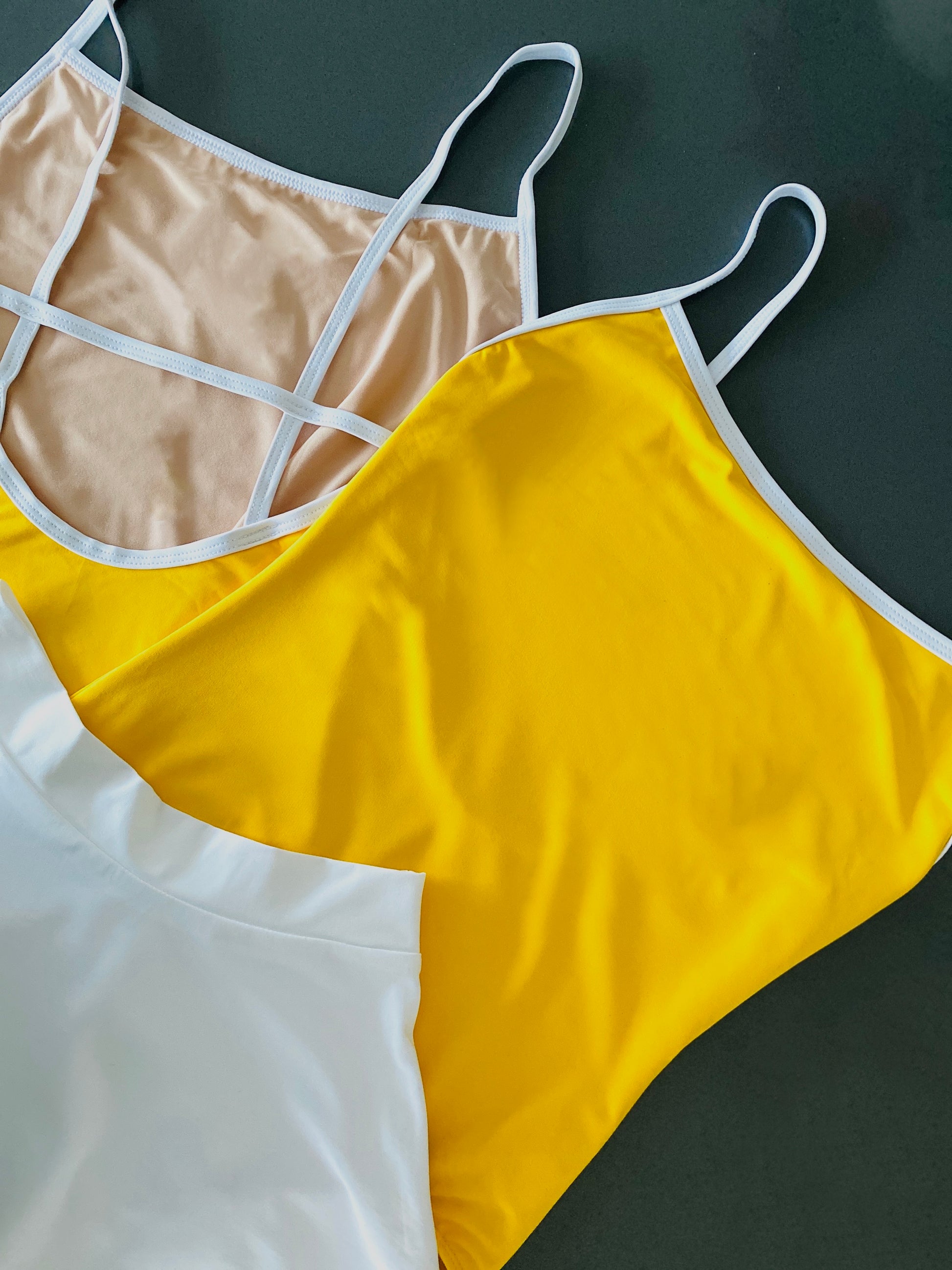 Yellow camisole leotard with white cross back from The Collective Dancewear with a white sab skirt 