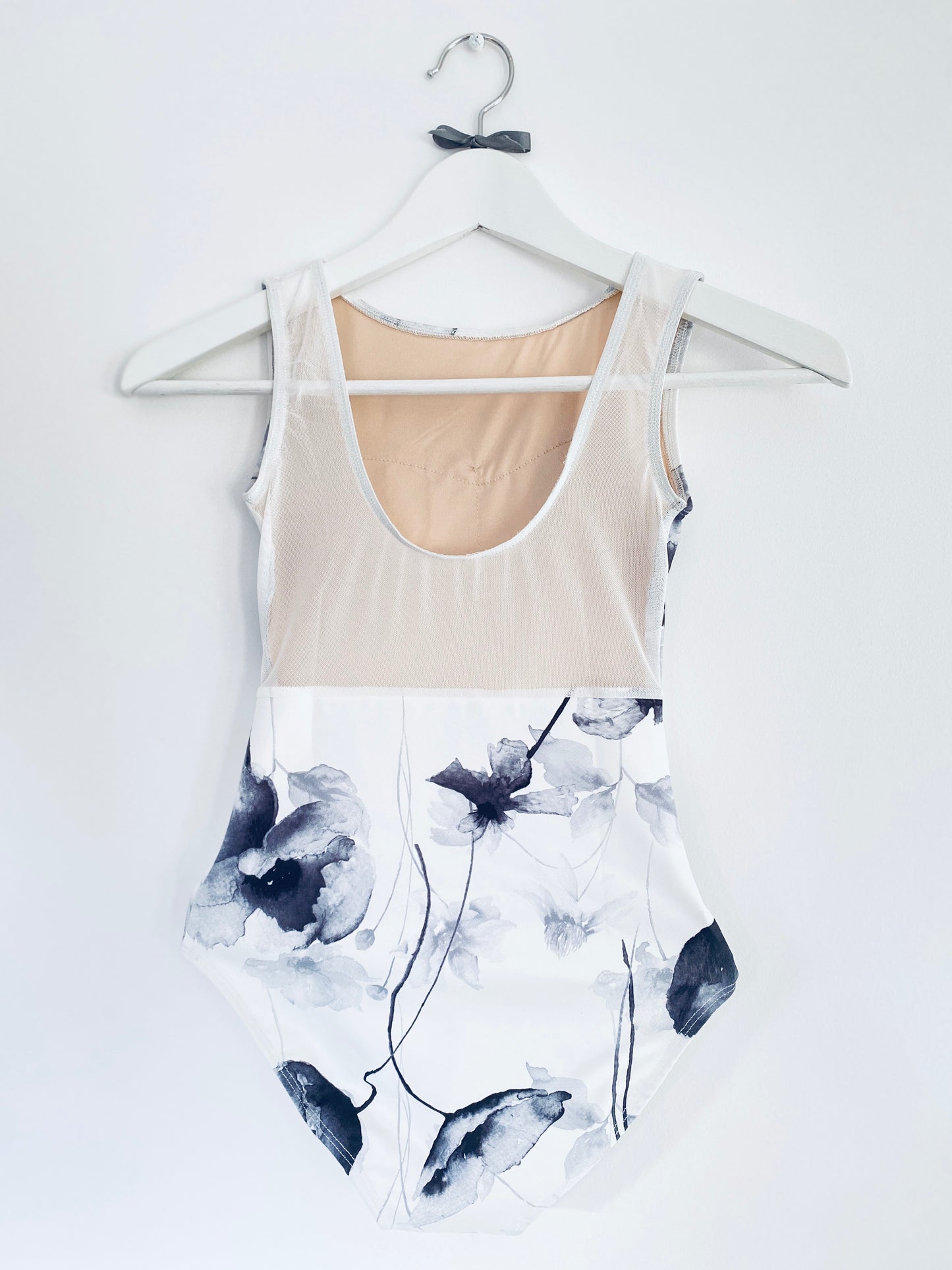 Sleeveless tank leotard with monochrome poppy pattern on white body from The Collective Dancewear