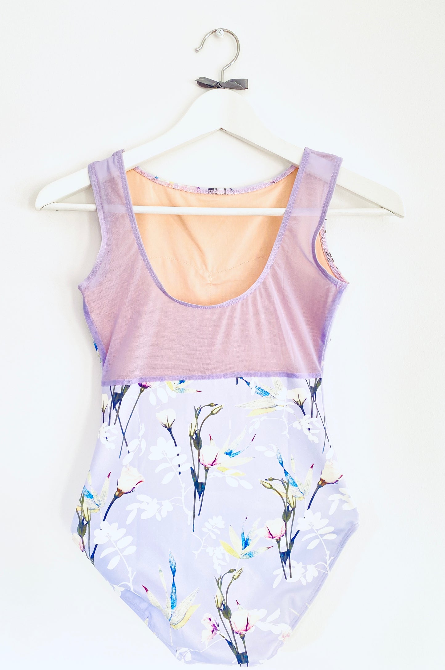 Sleeveless tank leotard with meadow flower pattern on a lilac background from The Collective Dancewear